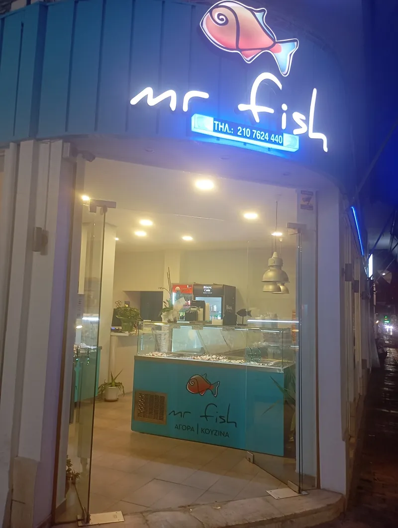 Το κατάστημα Mr. Fish στον Βύρωνα το βράδυ, με τη φωτεινή επιγραφή και το τηλέφωνο